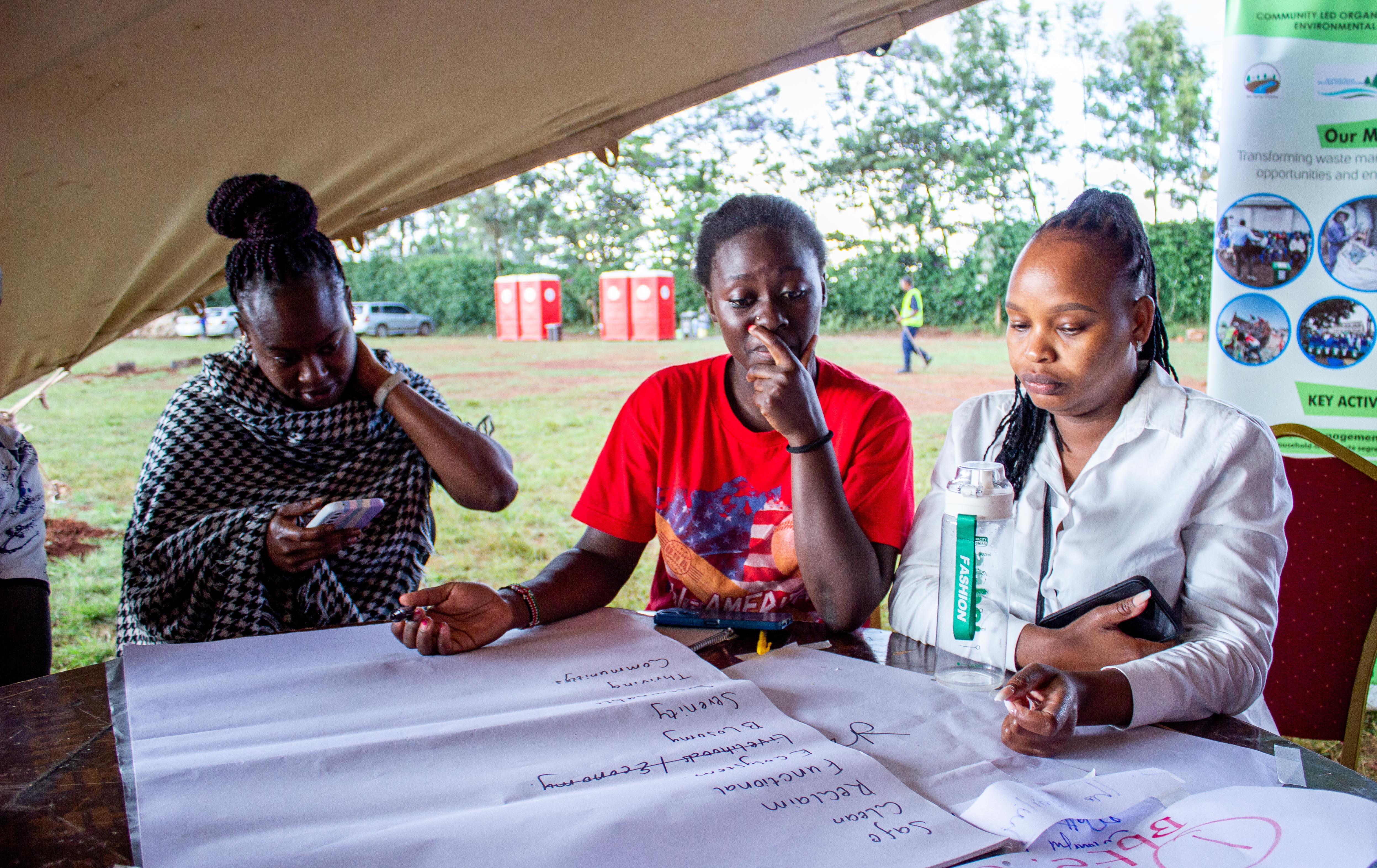 Obunji Moturi (WRA), Hedrique Mboya (community), and Fridah Mwarania (NCWSC) brainstorming before they burst into laughter a short moment after this..jpg